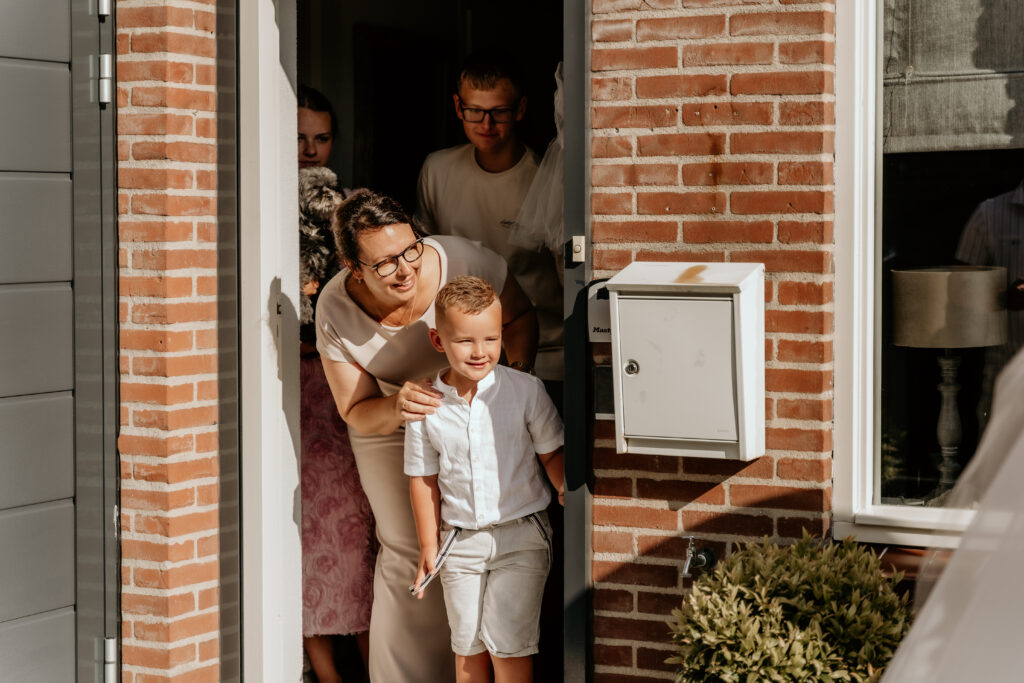 Familie kijkt naar bruidspaar tijdens first look bij bruiloft Zeeland