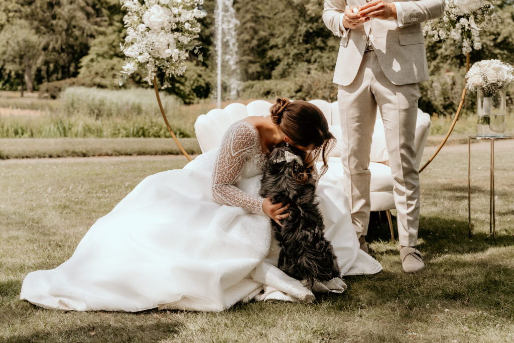 Bruid geeft emotionele knuffel aan  hond tijdens bruiloft 