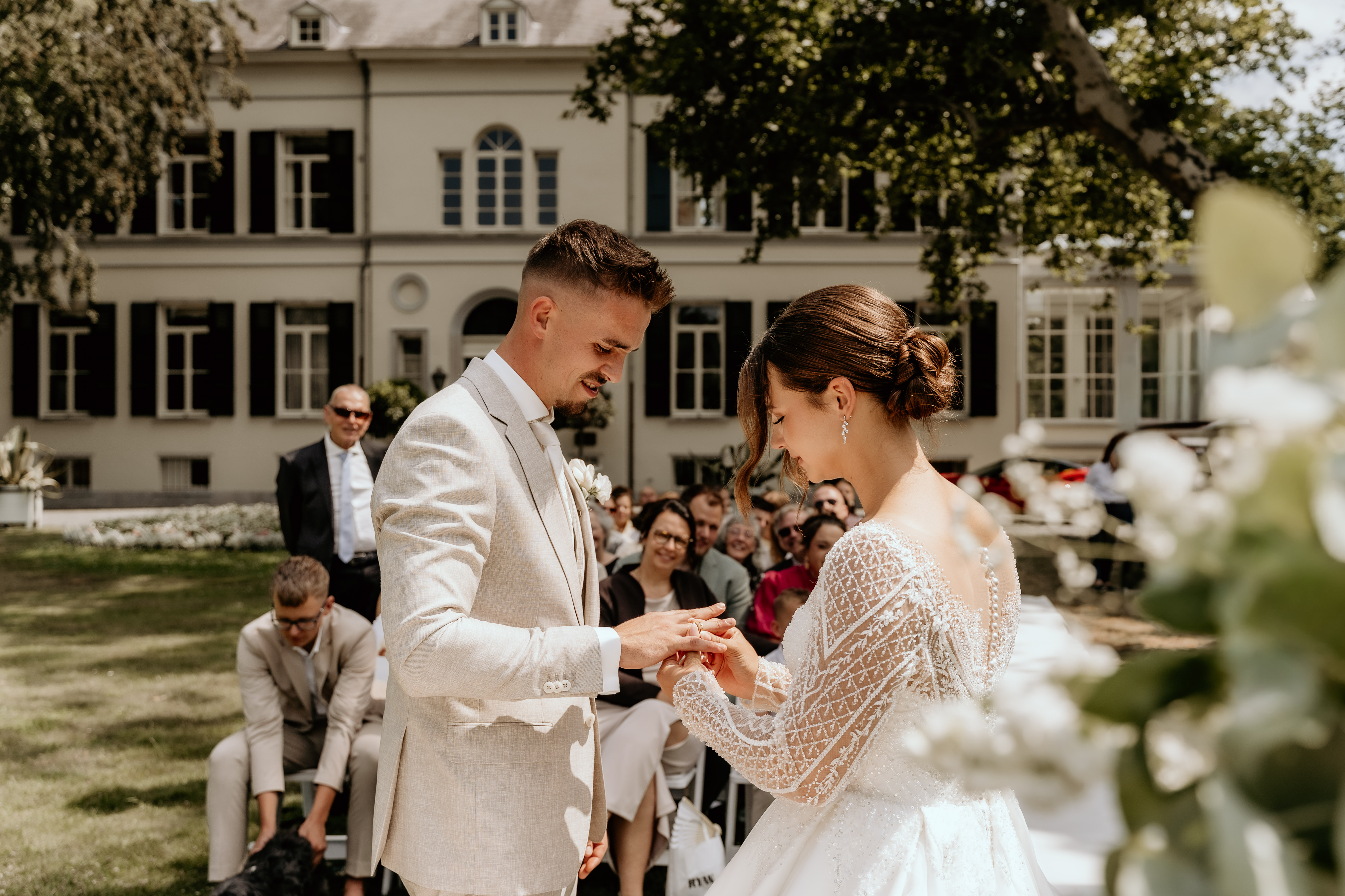 Bruidspaar doet ringen om tijdens ceremonie bij landgoed