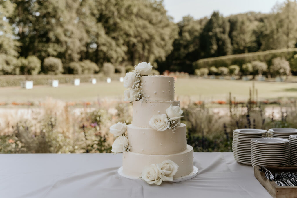 Witte bruidstaart met witte bloemen en parels