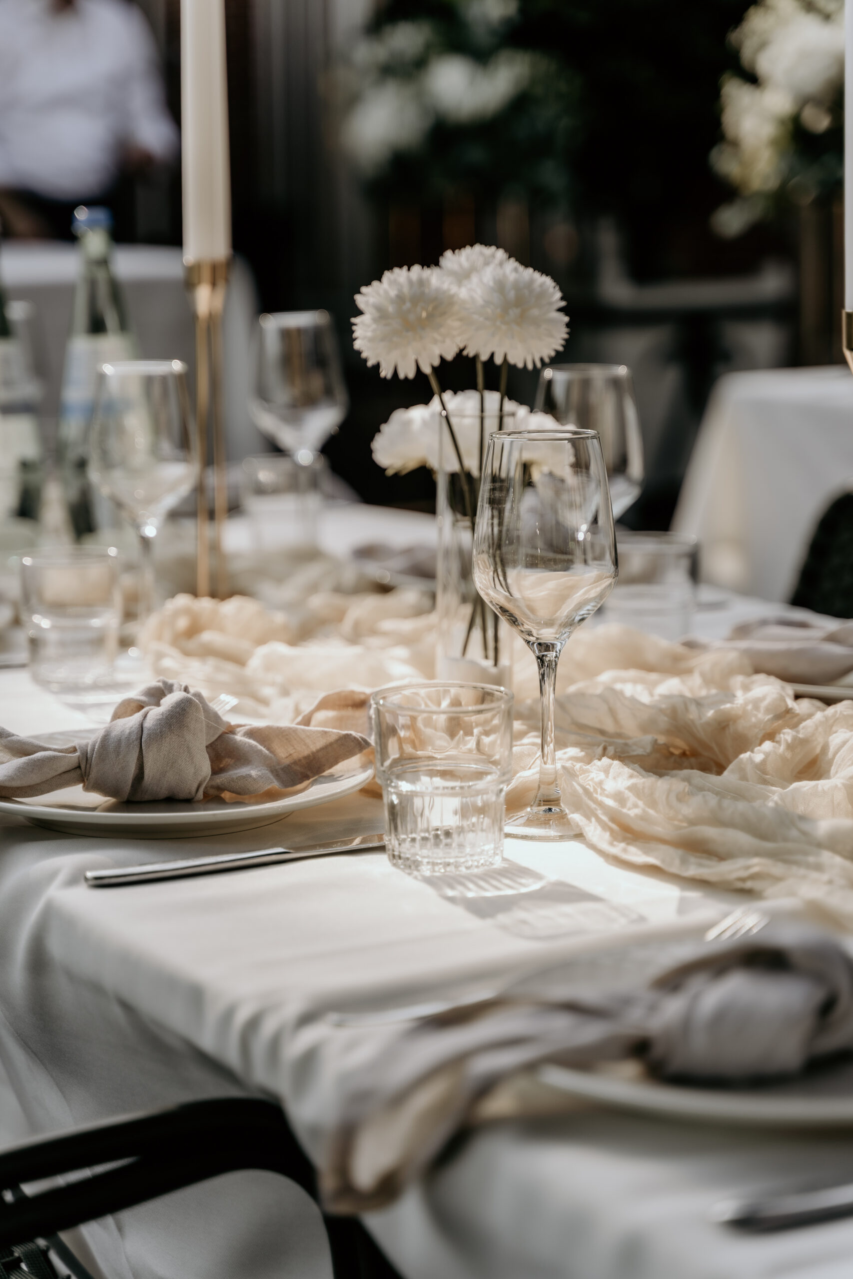 Bruiloft styling met witte bloemen op mooi gedekte tafel die klaar is voor diner.