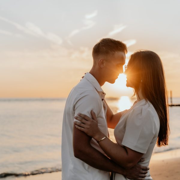 Koppel fotoshoot tijdens golden hour in de natuur in Zeeland op het strand voor spontane foto's.