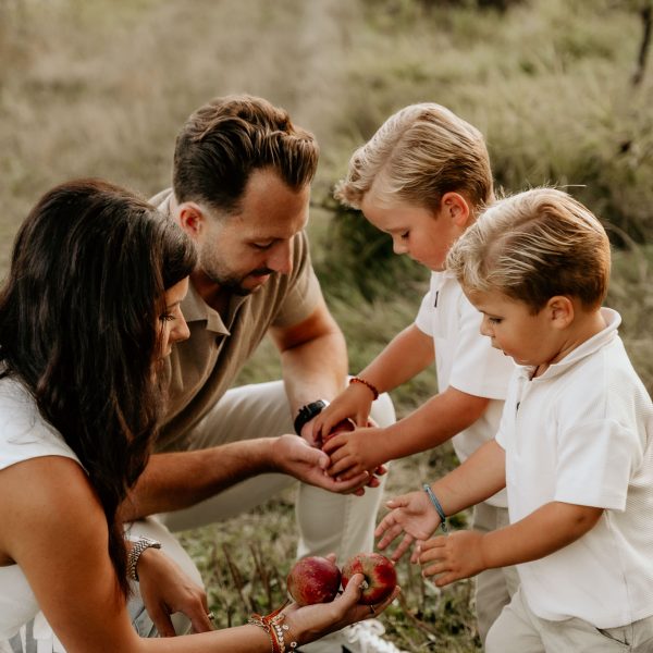 Gezinsfotoshoot tijdens golden hour in de natuur in Zeeland met spelende kinderen.