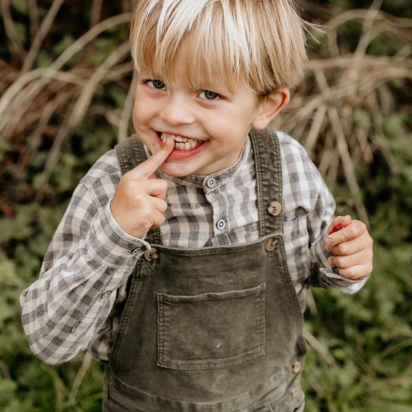 Gezinsfotoshoot tijdens golden hour in de natuur in Zeeland met spelende kinderen.